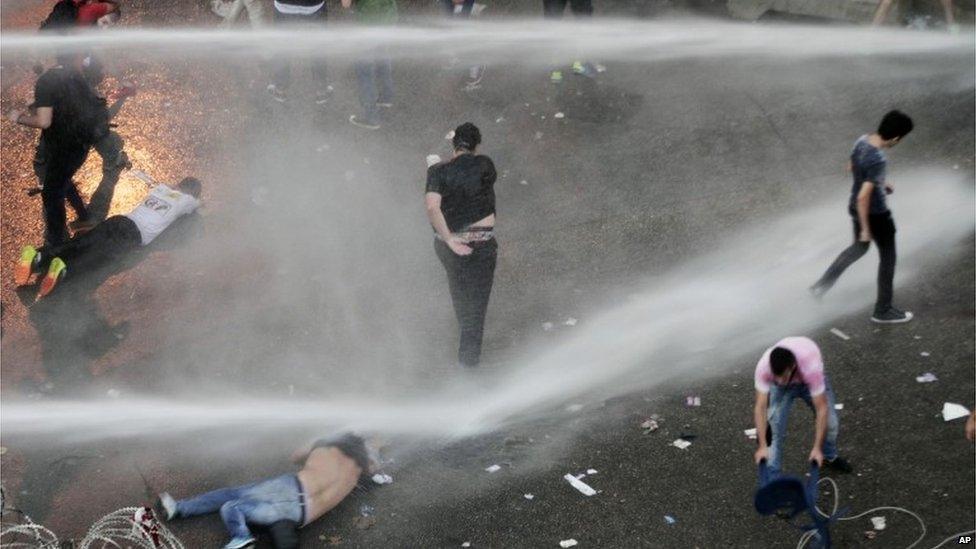 Lebanese activists are sprayed by riot police using water cannons in Beirut, 23 August 2015.