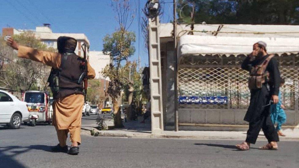 Image shows Taliban fighters closing road