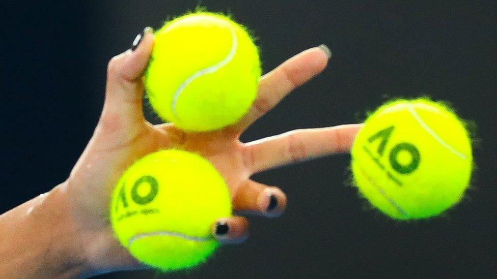 A close-up of three tennis balls in Madison Keys' hand.