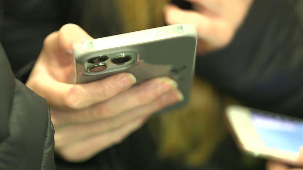 Teenagers hand holding a smart phone