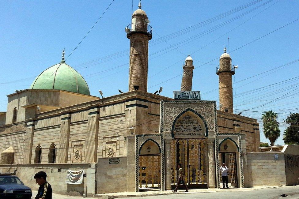 People walk in front of the Great Mosque of al-Nuri in Mosul, Iraq (9 July 2014)