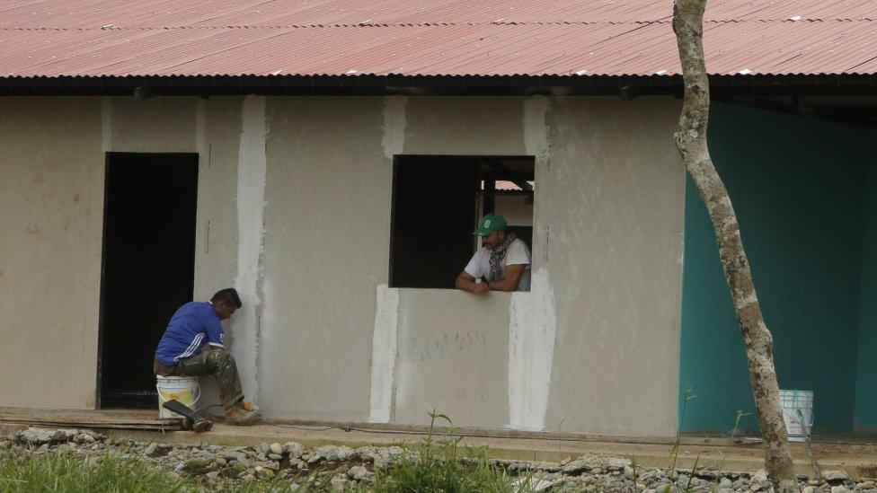 Two former rebels work on building the hotel