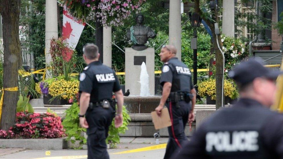 Police are seen near the scene of the shooting in Toronto, Canada, 23 July