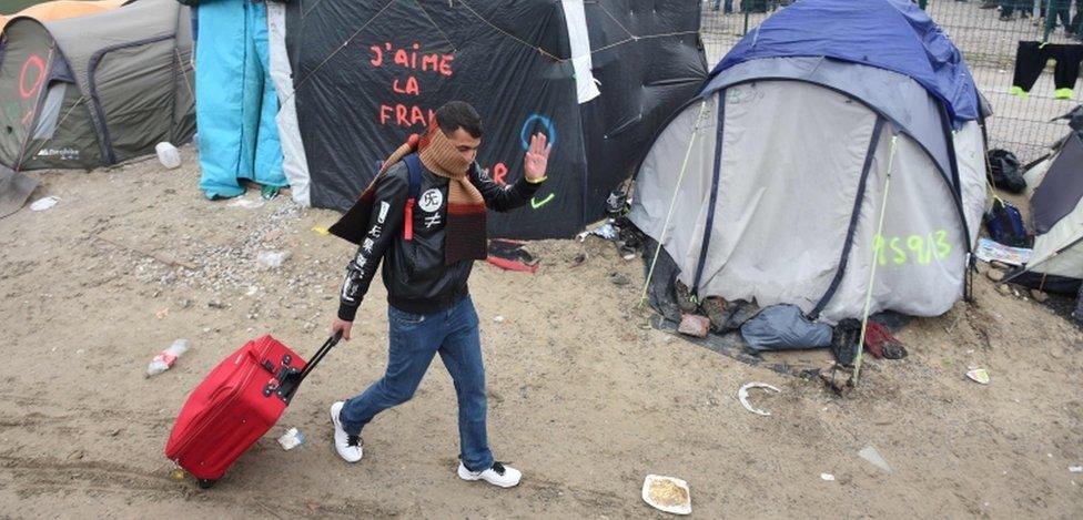 A migrant walks through the Jungle camp in Calais