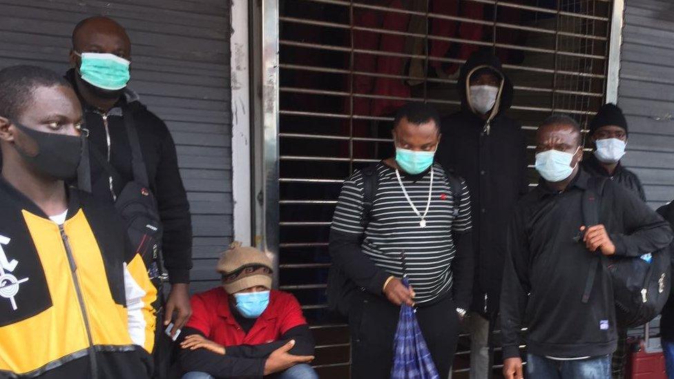 People standing outside a shop with face masks