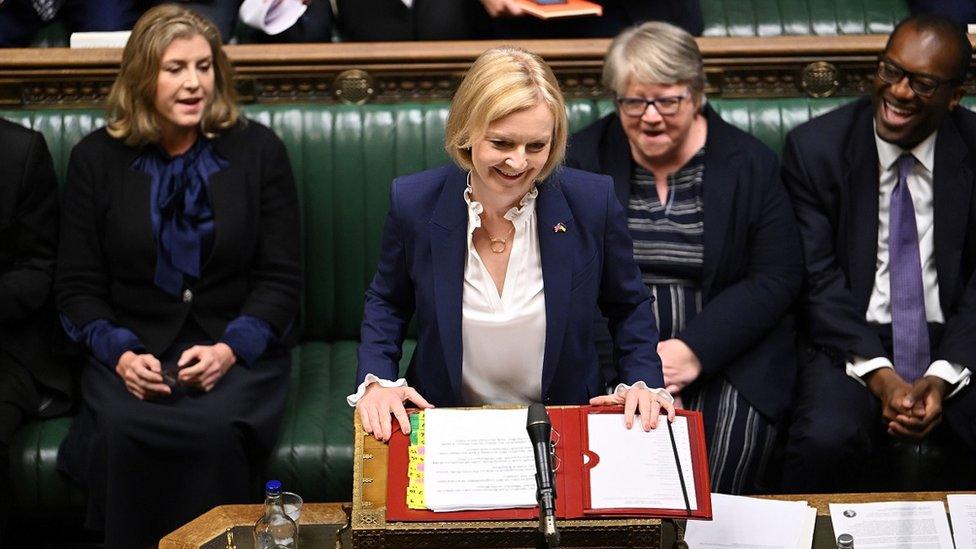 Liz truss smiling at the despatch box, flanked by Penny Mordaunt, Therese Coffey and Kwasi Kwarteng