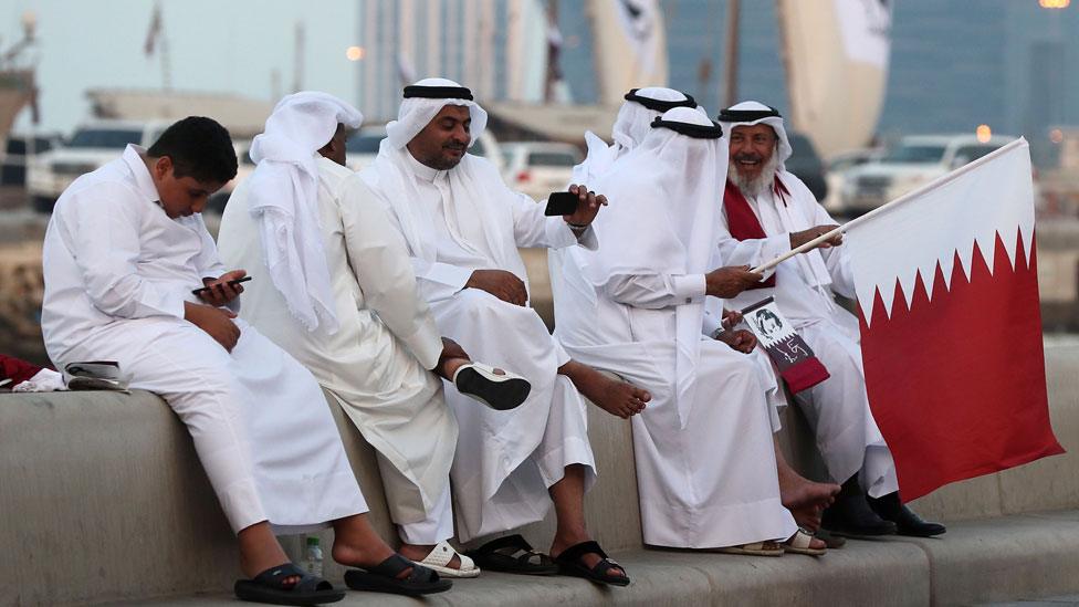 Qataris wave their national flag