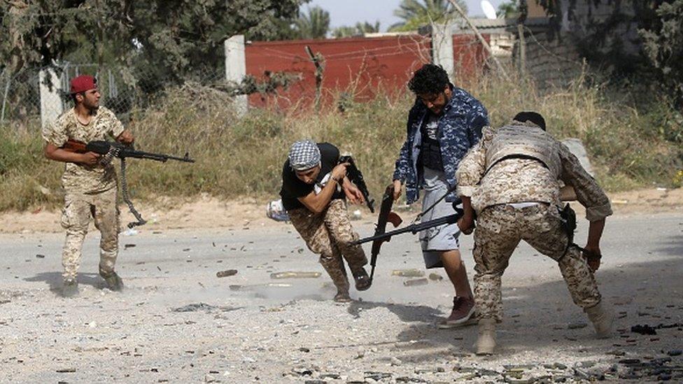 Libyan fighters loyal to the Government of National Accord (GNA) run as they fire their guns during clashes