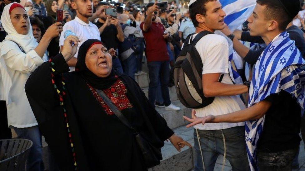 A Palestinian woman argues with Israelis during a flag march in Jerusalem's Old City (15 June 2021)