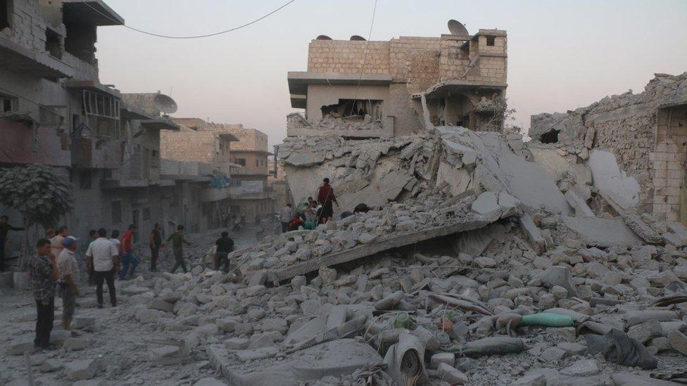 People inspect damaged buildings in Maarat al-Numan, Idlib province (28 August 2019)