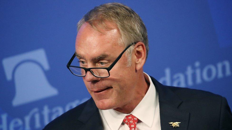 Ryan Zinke speaking in front of a blue background