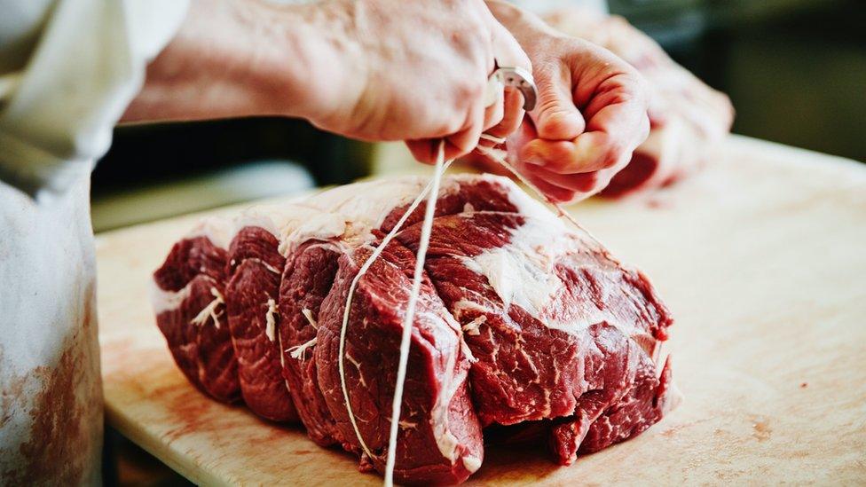 Butcher tying up meat