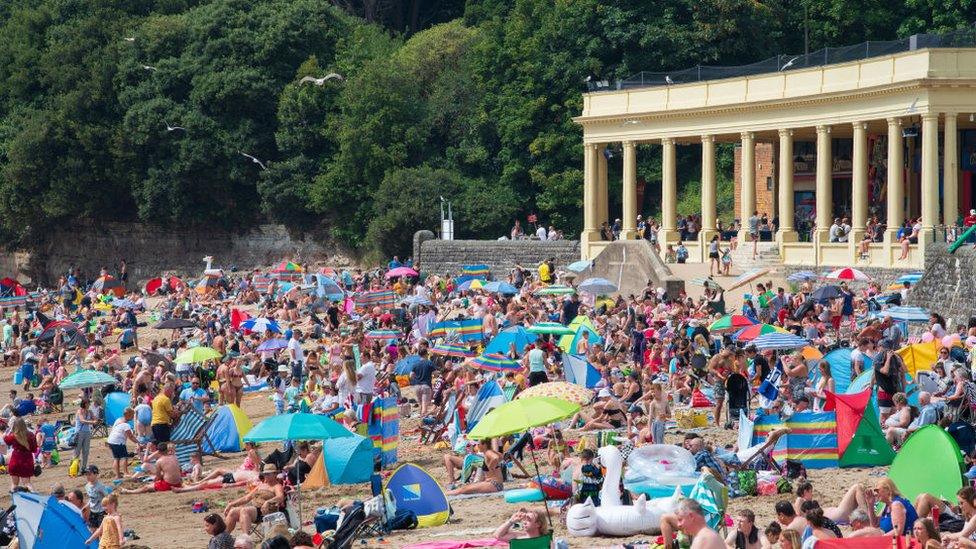 People enjoy the sun at Barry Island