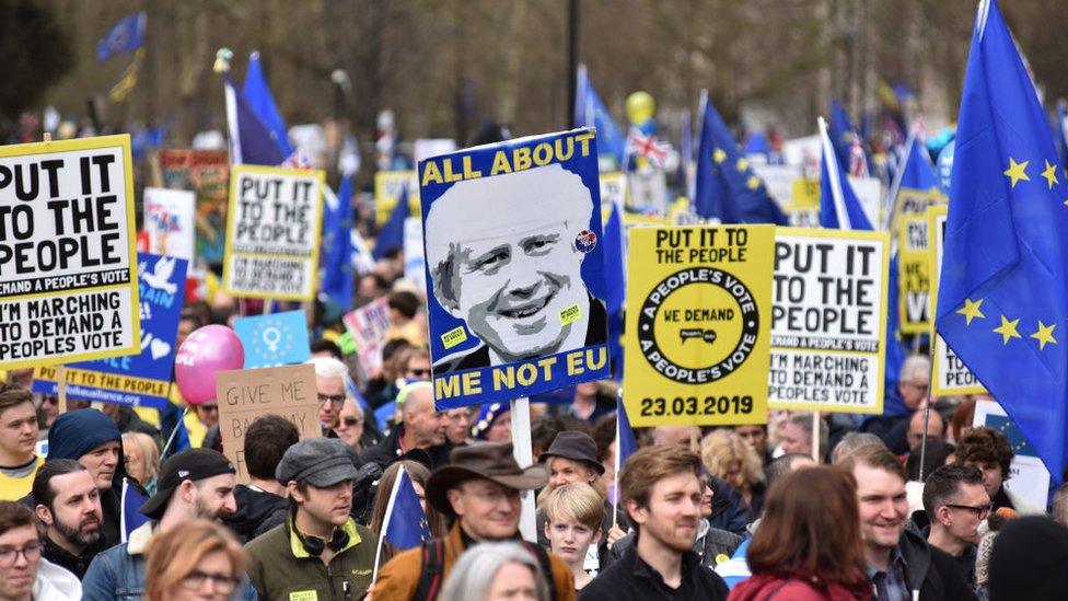 Protesters hold a placard showing a picture of Boris Johnson with the words 'All about me not EU' during the Put It To The People March on March 23, 2019 in London, England.