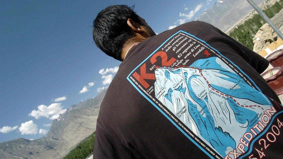 A man wears a t-shirt celebrating the fiftieth anniversary of the successful first climb of K2