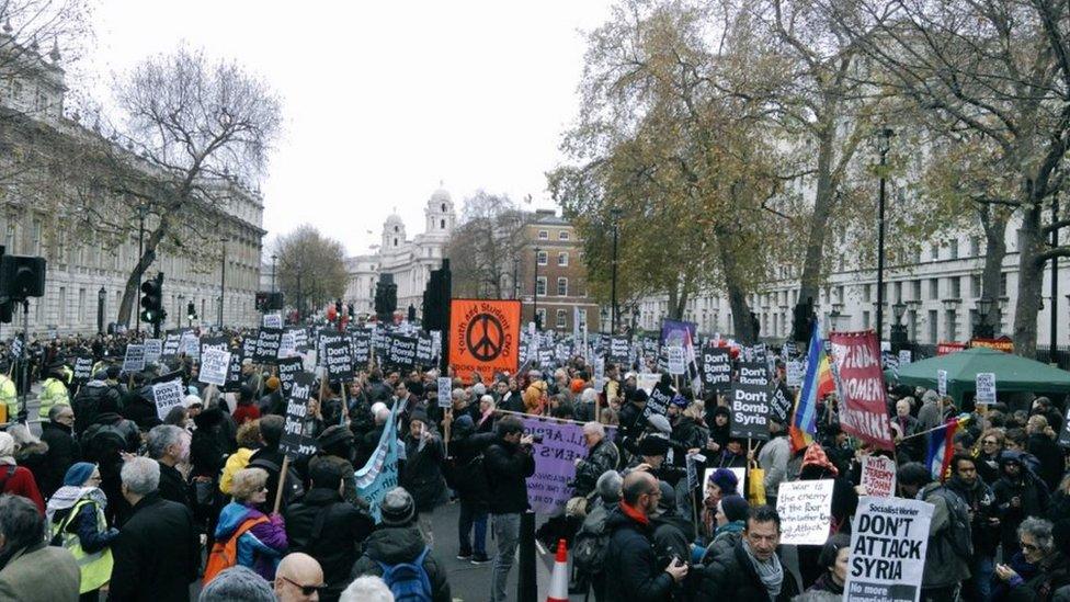 Hundreds carrying signs outside Downing Street.