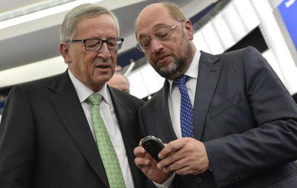 Martin Schulz, former president of the European Parliament, stares at a phone with Jean-Claude Juncker, president of the European Commission