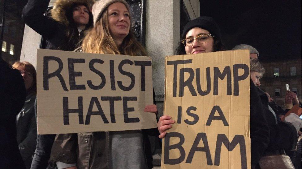 Protesters at the Trump travel ban demo in Glasgow - one sign saying 'resist hate', the other saying 'Trump is a bam'