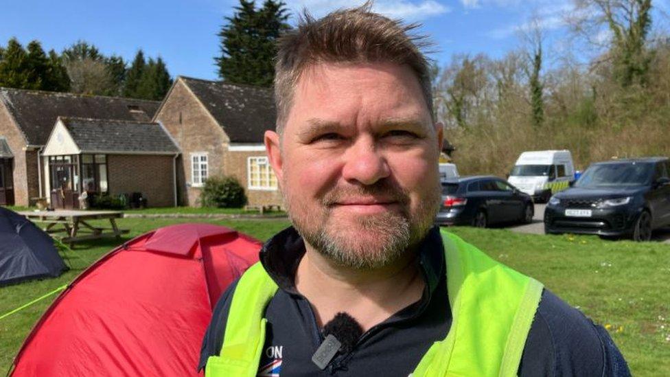 Dan Cooke is wearing a high-vis jacket and smiling at the camera