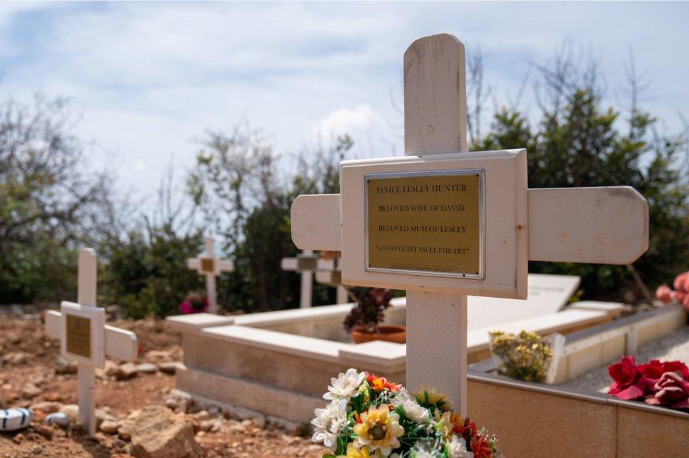 A cross in a graveyard with Janice's name on it