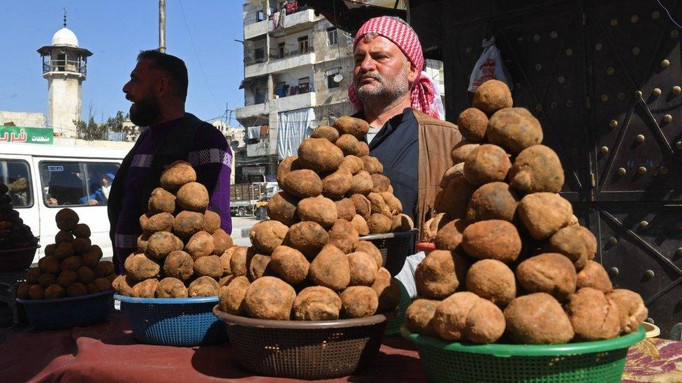 A Syrian man sells desert truffles at a market in the city of Aleppo (28 February 2024)