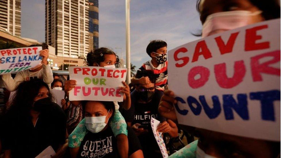 Children holding placards are carried by their guardians as they take part during the protest against Sri Lankan President Gotabaya Rajapaksa, near the Presidential Secretariat, amid the country"s economic crisis, in Colombo, Sri Lanka, April 15, 2022.