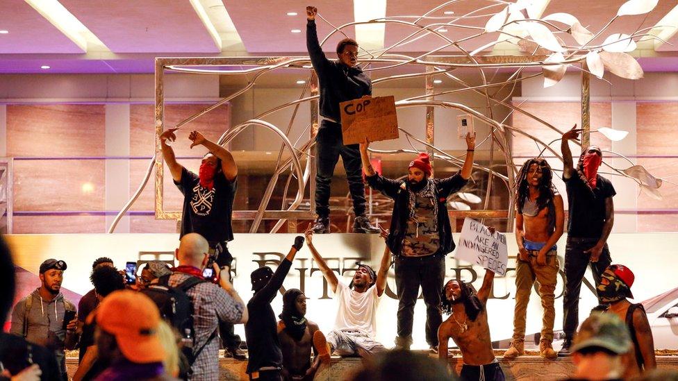 People gather in front of the Ritz-Carlton in Charlotte, North Carolina, during a protest on 21 September