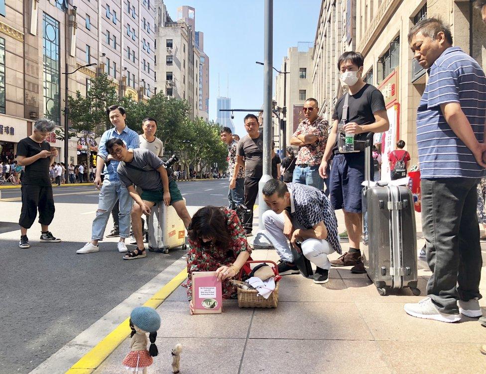 Eileen Lam setting up a photo of the dolls