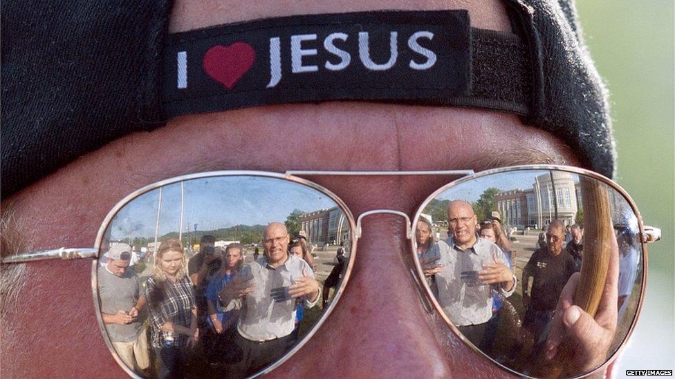 The reflection of a man speaking with protestors in opposition of same sex marriage is reflected in the sun glasses of Mike Reynolds, a opposer of same sex marriage, during a protest in front of the Rowan County Courthouse on 3 September 2015 in Morehead, Kentucky.