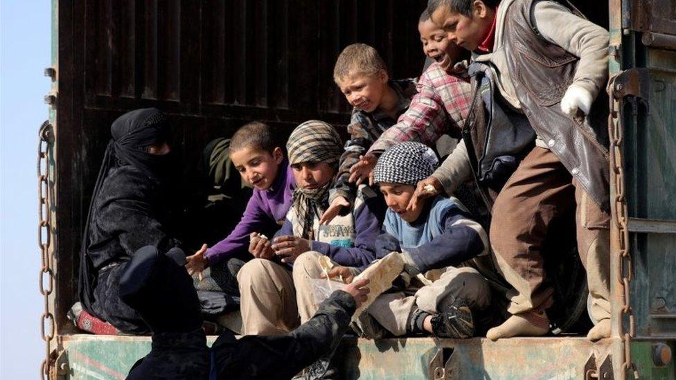 A fighter from the Syrian Democratic Forces (SDF) gives bread to children near the village of Baghouz, Deir Al Zor province, Syria on 20 February 2019.