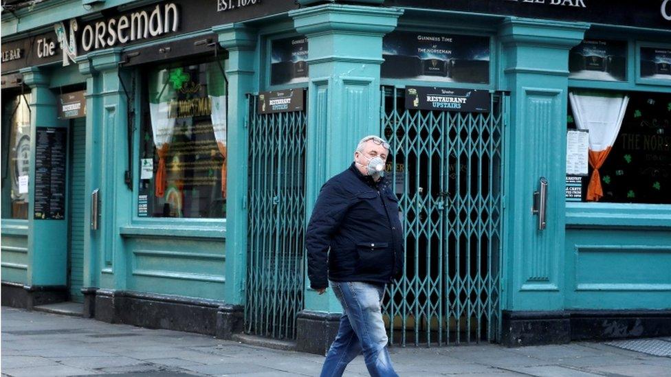 A man wearing a protective face mask passes Dublin's Norseman pub