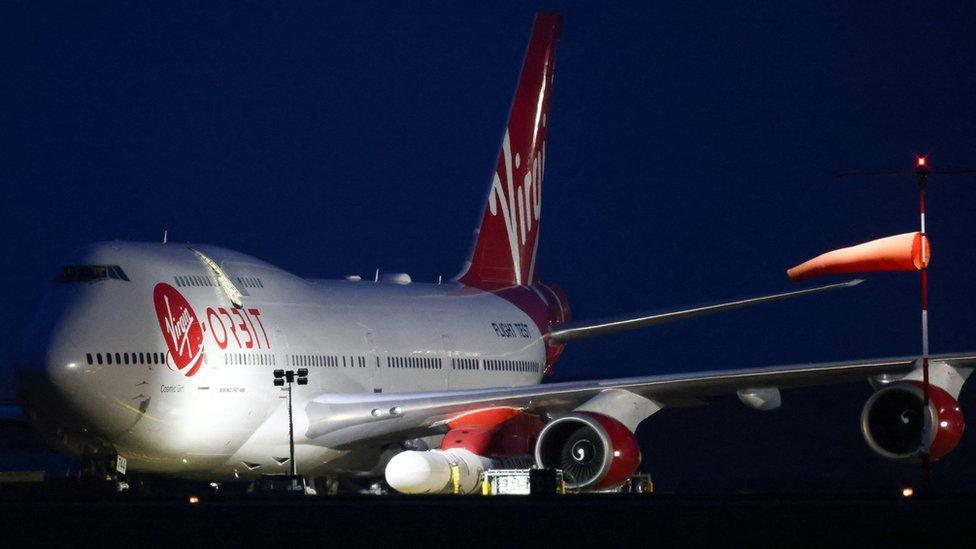 A Virgin Boeing 747-400 aircraft sits on the tarmac with Virgin Orbit's LauncherOne rocket attached to the wing at Spaceport Cornwall at Newquay Airport in Newquay