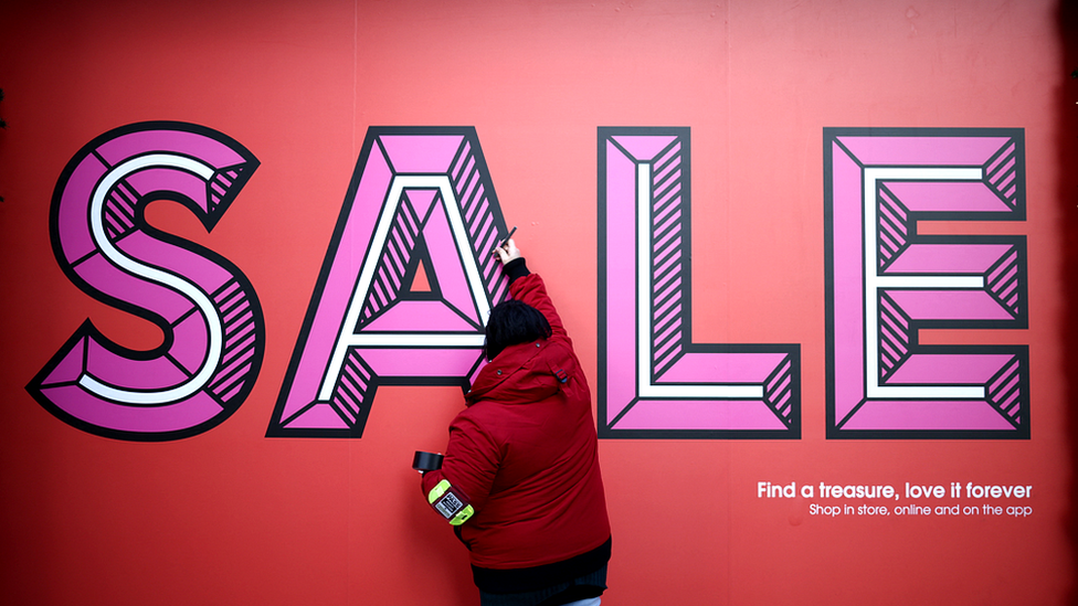 Woman painting sale sign