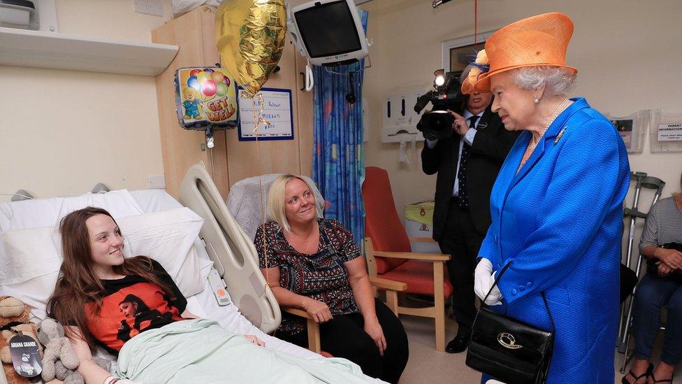 Queen Elizabeth II speaks to Millie Robson, 15, from Co Durham, and her mother, Marie, during a visit to the Royal Manchester Children's Hospital to meet victims of the terror attack on May 25, 2017 in Manchester