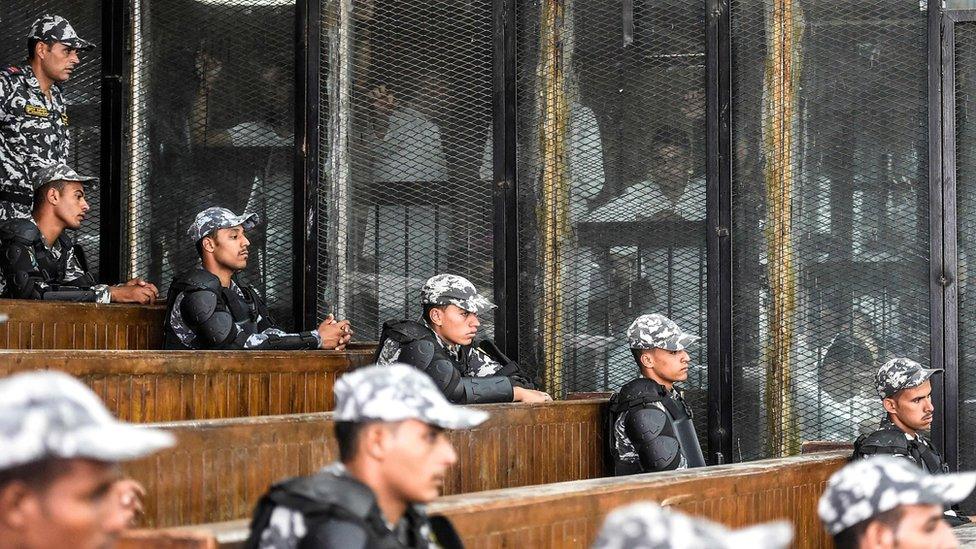 Members of Egypt's banned Muslim Brotherhood are seen inside a glass dock during their trial in the capital Cairo on July 28, 2018