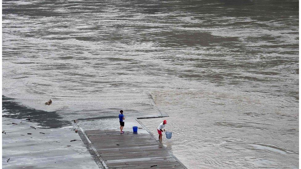 Local residents catch fish from the Xindian river after typhoon Megi passed Xindian district in New Taipei City on 28 September 2016.