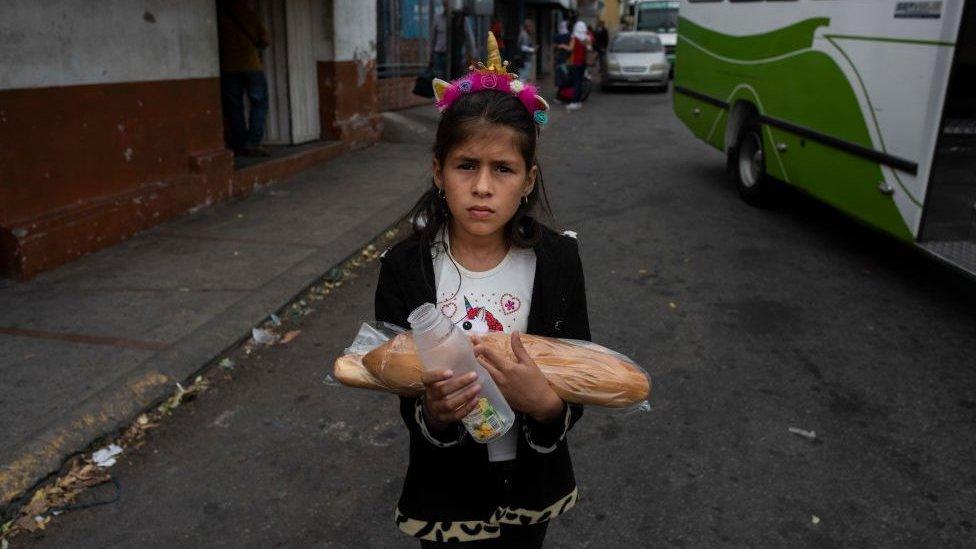 A girl follows her mother towards the border with Colombia in the border town of San Antonio, Venezuela on February 19, 2019.