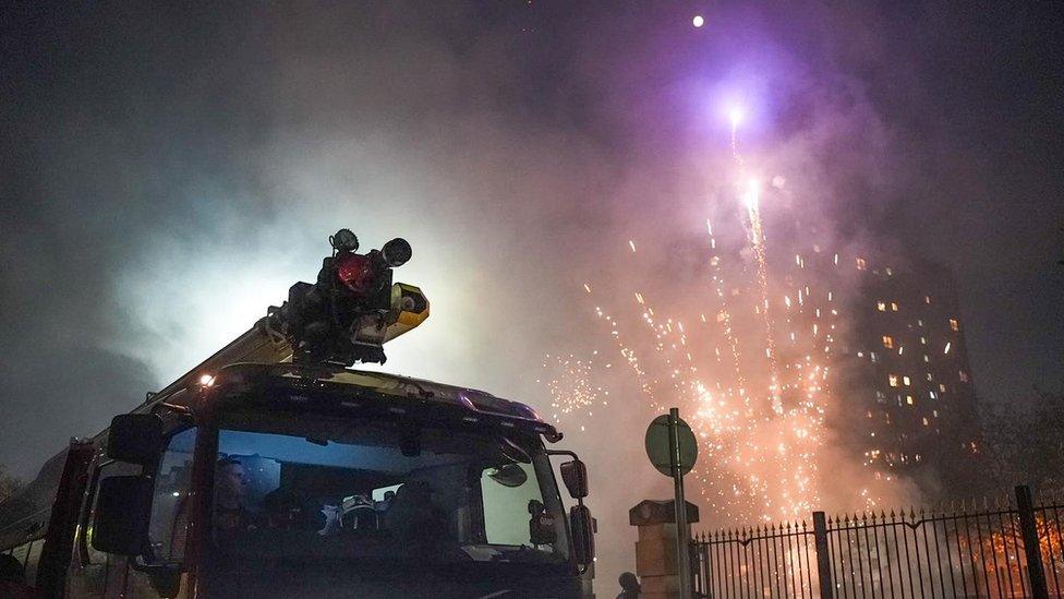 Fire engine with firework exploding nearby