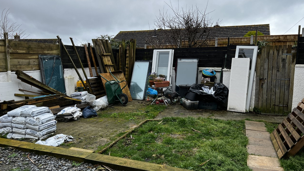 Garden at the back of their house with building materials