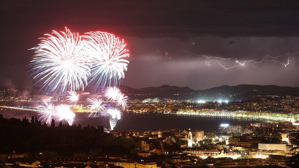 Panoramic shot of Nice, showing fireworks, the sea and a lightning storm in the distance, 14 July 2016.