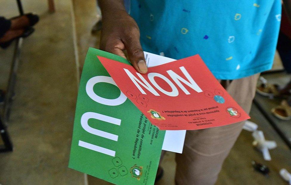 A man holds ballots before voting for a referendum on a new constitution on October 30, 2016 at a polling station in Yopougon, suburb of Abidjan