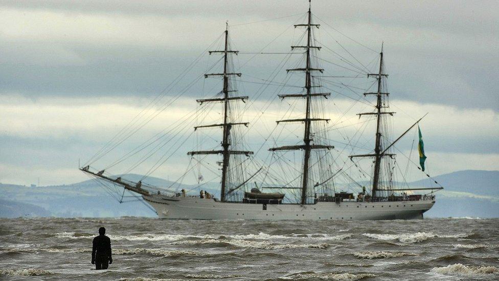 Figure from Antony Gormley's 'Another Place' welcomes one of the Tall Ships to Merseyside as it sails past the Burbo Bank windfarm on the approach to the Port of Liverpool on July 18, 2008