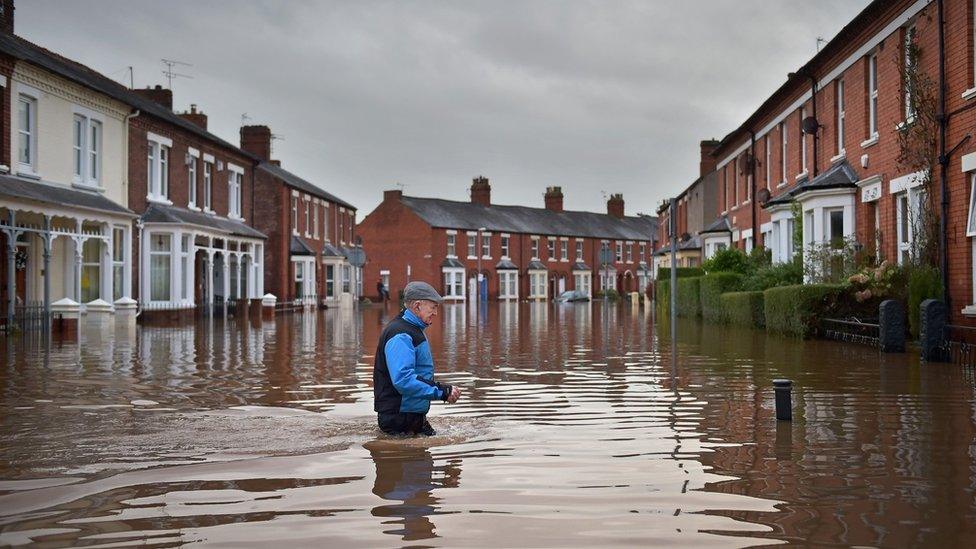 A Carlisle resident makes his way through the floodwater