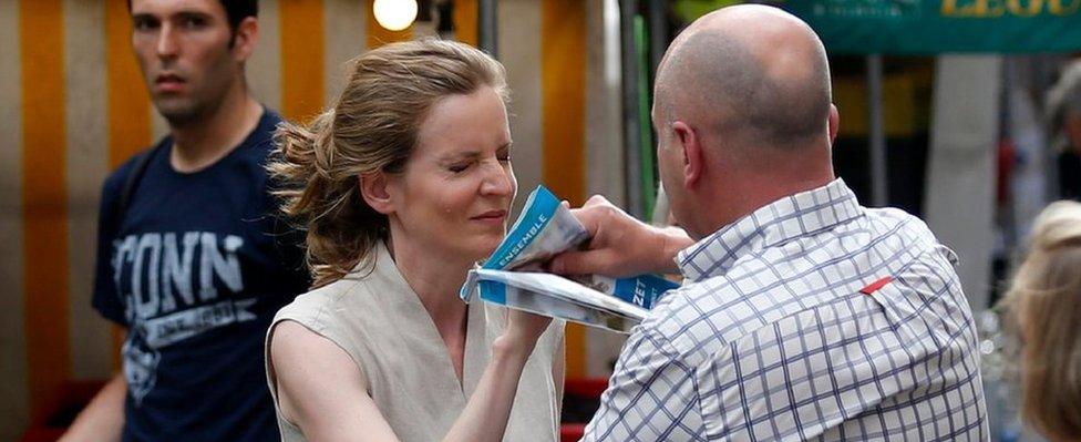 A passerby takes leaflets from the hand of Les Republicains (LR) party candidate Nathalie Kosciusko-Morizet during an altercation while campaigning in the 5th arrondissement in Paris on June 15, 2017,