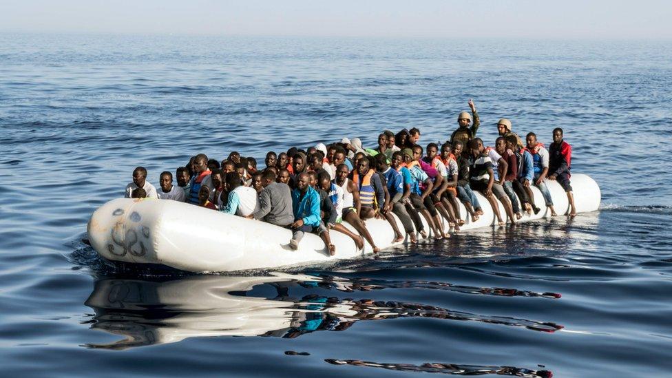 Migrant crisis: Libyan coast guardsmen at sea in an overcrowded dingy with illegal immigrants that were rescued, June 2017