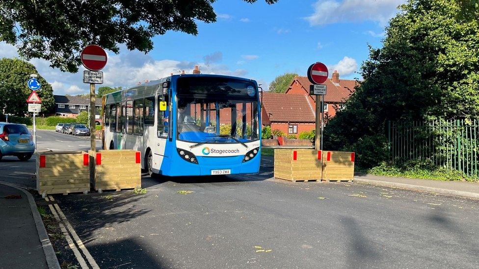 Bus going through the planters on Whipton Lane