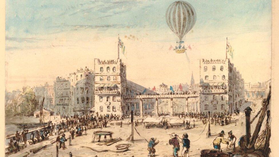 print of a hot air balloon floating over buildings and a square in 1800s Europe