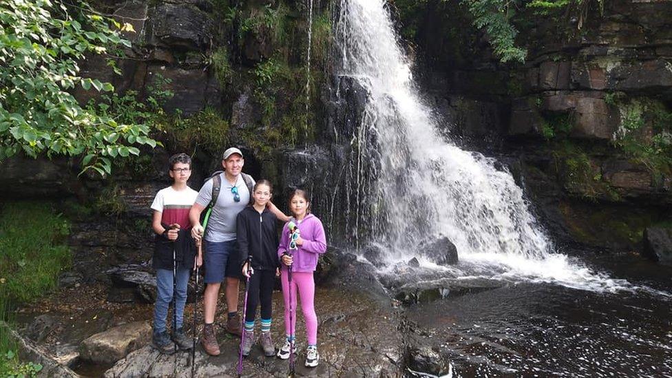 Sam Rushworth (second left) with Eden, Amelie and Jesse in front of a waterfall at Keld in the Yorkshire Dales