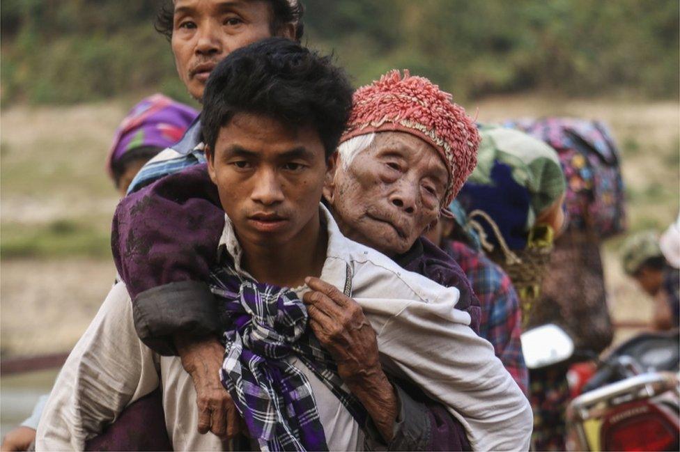 Displaced Kachin residents crossing Malikha river on a ferry to escape the fighting, on 26 April 2018