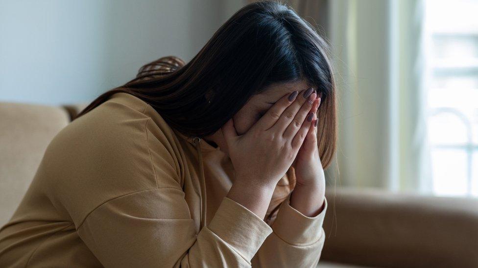 Women with hands covering her face